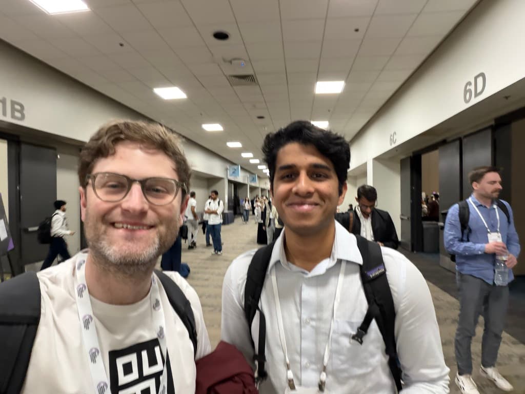 Aniruddhan with a fellow attendee in the hallways of NeurIPS 2025